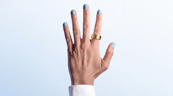 Hand met de SyncGear Smart Ring in goud om de ringvinger