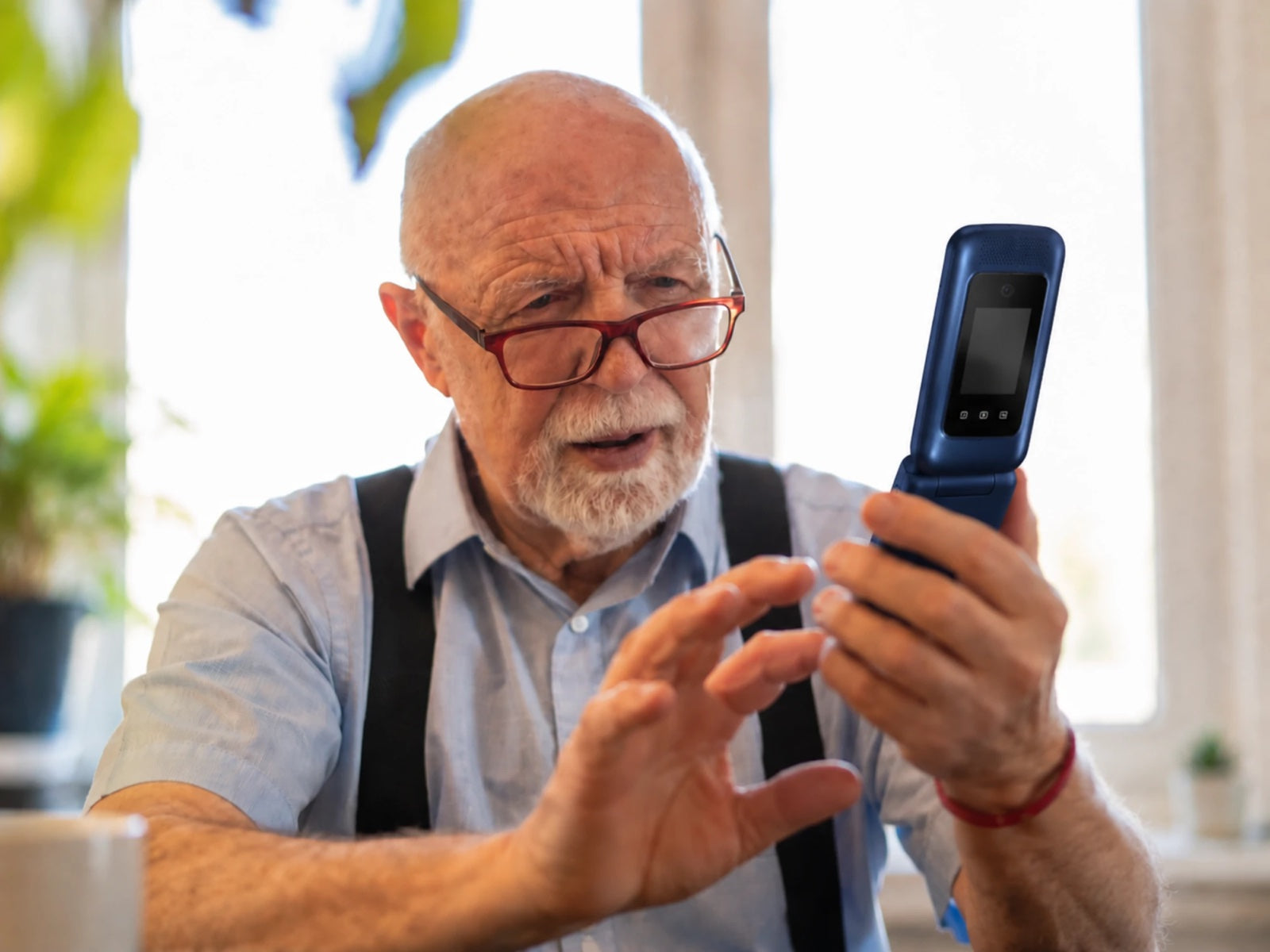 Een oudere man klapt de SyncGear Flip GSM open om te bellen